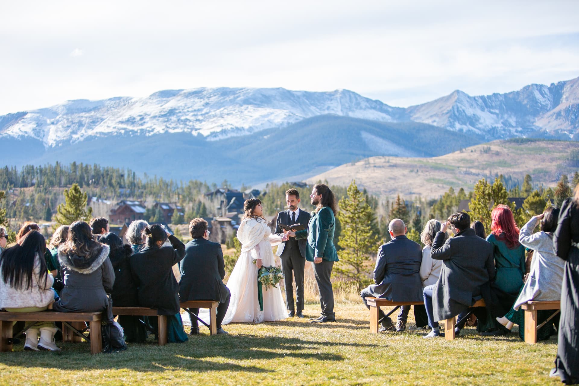 A wedding group gathered below snow-capped Colorado peaks