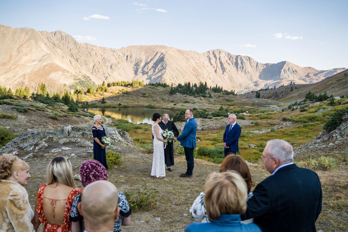 A couple marrying beside an alpine lake at Loveland Pass in the Colorado mountains